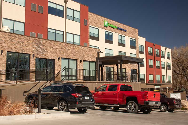 This photo shows the new Holiday Inn Express Hotel against a blue sky with vehicles in the parking lot. Manitou Springs Urban Renewal Authority Success Stories. This photo shows the new Holiday Inn Express Hotel against a blue sky with vehicles in the parking lot. Manitou Springs Urban Renewal Authority Success Stories.