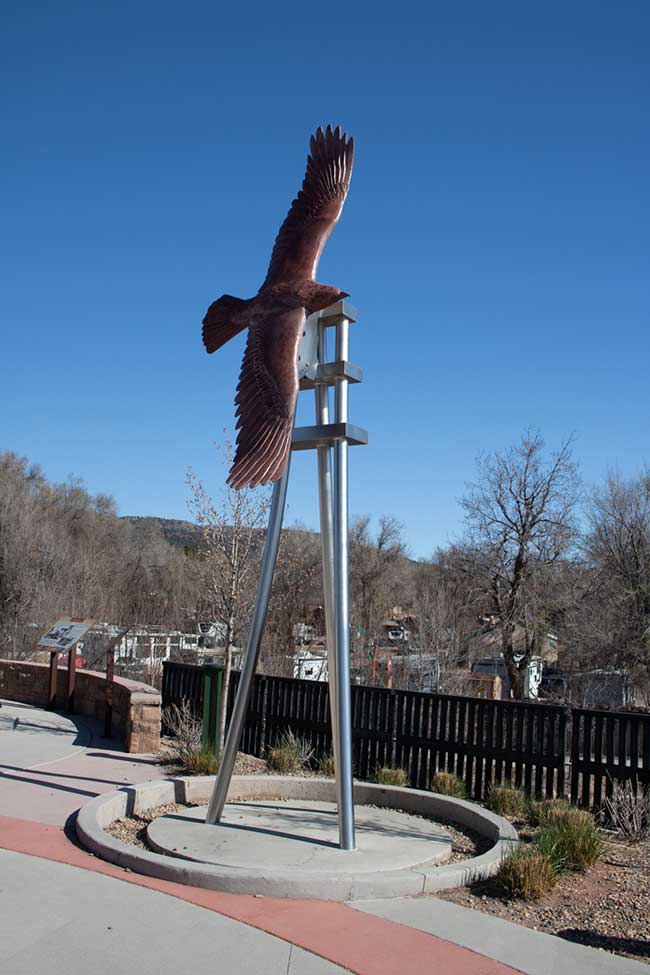 This is Soaring Eagle, a sculpture made from Rocky Mountain granite. It is an eagle in flight against a blue sky. Manitou Springs Urban Renewal Authority Success Stories. This is Soaring Eagle, a sculpture made from Rocky Mountain granite. It is an eagle in flight against a blue sky. Manitou Springs Urban Renewal Authority Success Stories.